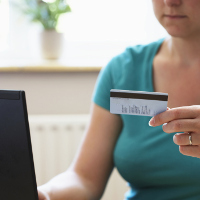 Una mujer introduciendo los datos de su tarjeta de crédito para pagar online.