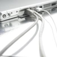 Cables conectados a un ordenador portátil blanco.